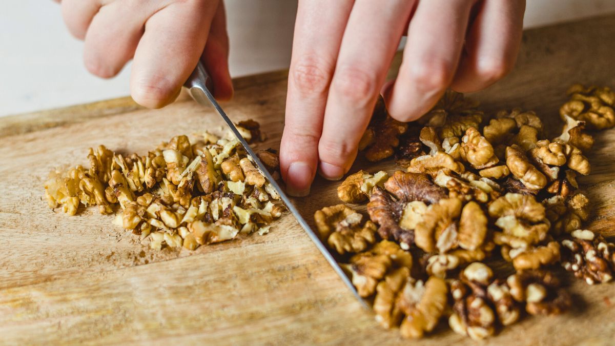 Kobieta kroi na desce orzechy włoskie