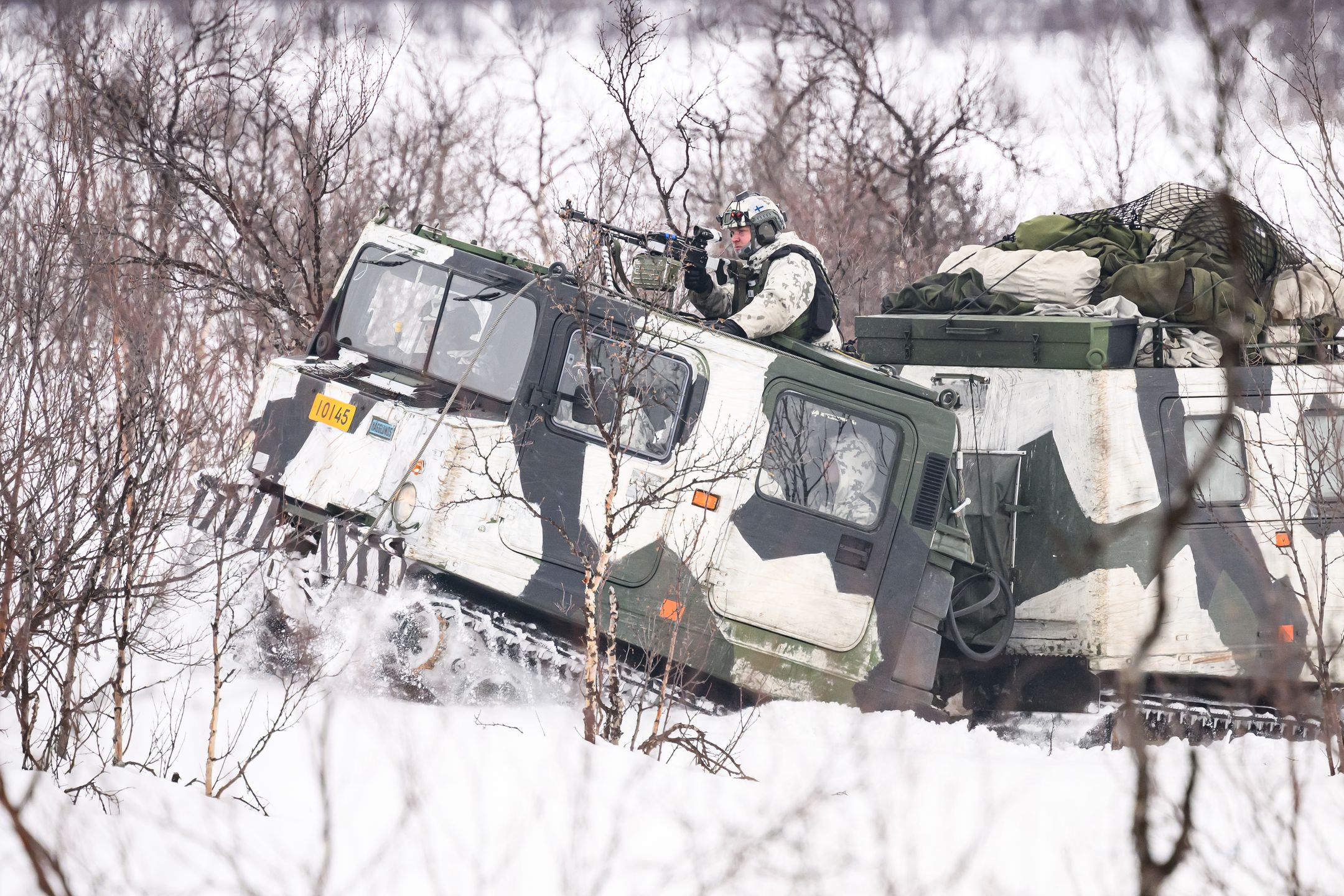 KIVILOMPOLO, FINLAND - MARCH 09: Finnish soldiers drive a BVS10 armoured vehicle as they take part in an exchange of fire with "enemy troops" during a training exercise, visible to the media, on the Finland/Norway border during the Nordic Response military exercise on March 09, 2024 in Kivilompolo, Finland. The exercise, which primarily takes place across Scandinavia from March 3-14, features 20,000 troops from 13 allied countries. Following the recent NATO expansion, the group now includes Finland and Sweden. (Photo by Leon Neal/Getty Images)