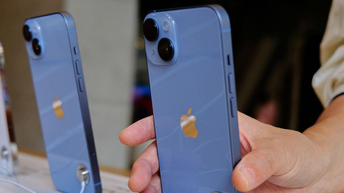 TIANJIN, CHINA - 2022/10/12: A customer is picking up a sample iPhone 14 in an Apple store.  On October 7, the iPhone 14 series were launched in the Chinese Mainland market. According to the latest report, Apple Inc. will cancel the plan to increase the production of 6 million iPhones 14 series because the demand is lower than expected. (Photo by Zhang Peng/LightRocket via Getty Images)