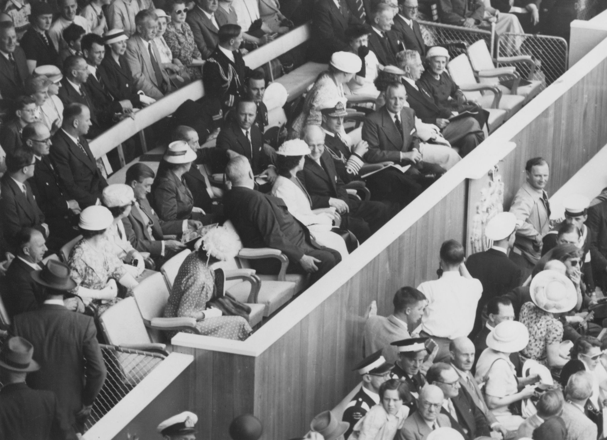 Książę Filip w mundurze marynarki wojennej, wśród dygnitarzy obserwujących paradę sportowców - ceremonia otwarcia Letnich Igrzysk Olimpijskich w  Melbourne 1956.