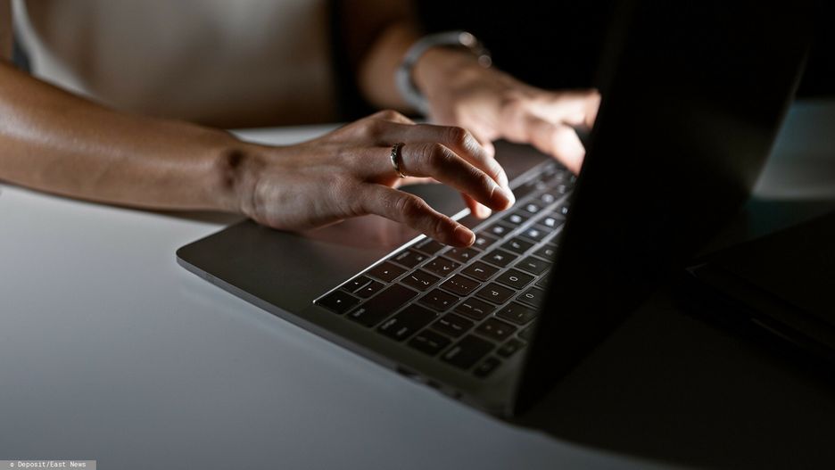 Deposit Photos 2024-05-21
Close-up of a young woman typing on a laptop in a dimly lit room, reflecting professionalism and focus.