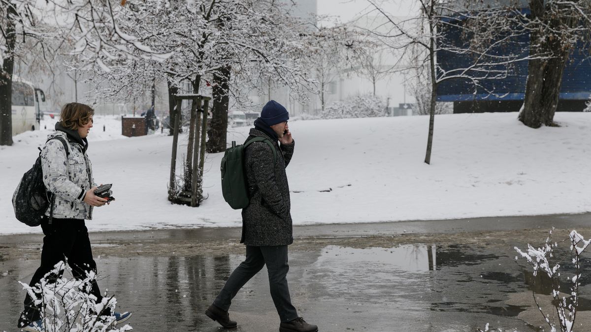 WARSAW, POLAND - 2026/01/28: People walk in central Warsaw on a snowy day. Snowfall overnight covered the city streets in Warsaw. Pedestrians and commuters move through fresh snow as winter weather settles in the capital. (Photo by Volha Shukaila/SOPA Images/LightRocket via Getty Images)