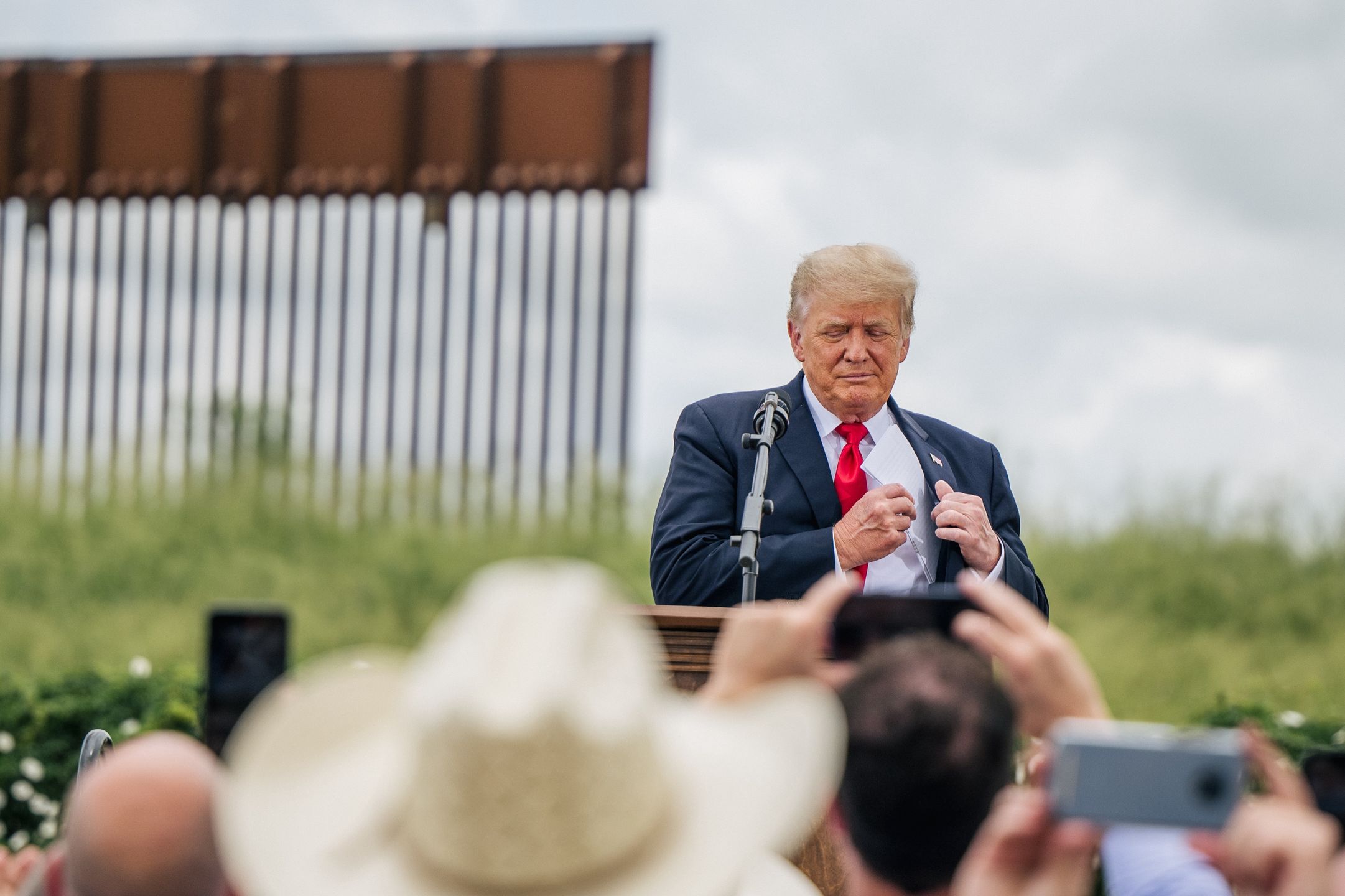 Former President Trump Joins TX Gov. Abbott At Unfinished Border WallPHARR, TEXAS - JUNE 30: Former President Donald Trump pulls out his notes before speaking during a tour to an unfinished section of the border wall on June 30, 2021 in Pharr, Texas. Gov. Abbott has pledged to build a state-funded border wall between Texas and Mexico as a surge of mostly Central American immigrants crossing into the United States has challenged U.S. immigration agencies. So far in 2021, U.S. Border Patrol agents have apprehended more than 900,000 immigrants crossing into the United States on the southern border.  (Photo by Brandon Bell/Getty Images)Brandon Bell