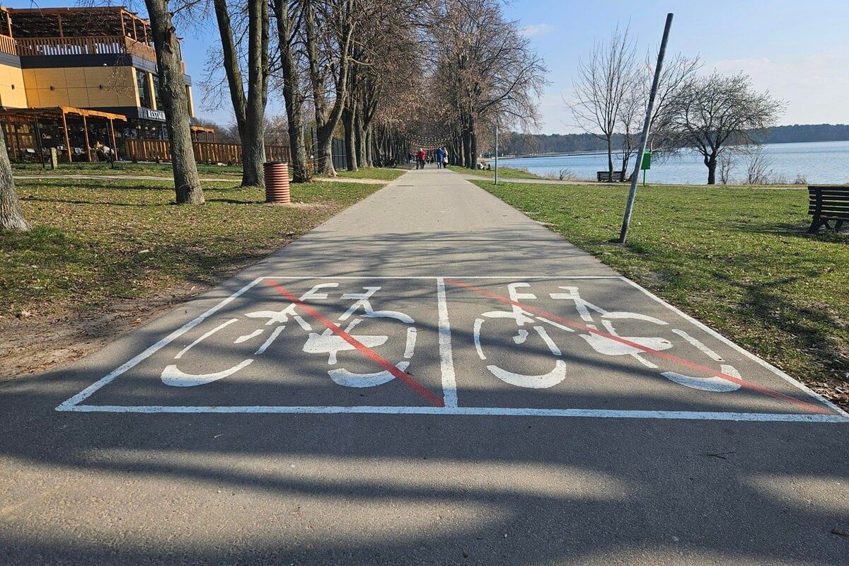 Znak informujący o zakazie jazdy rowerem po ścieżce przy Zalewie Zemborzyckim