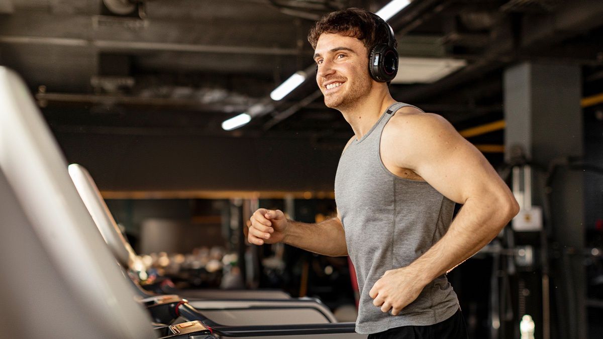 Mężczyzna biegnący na bieżni na siłowni