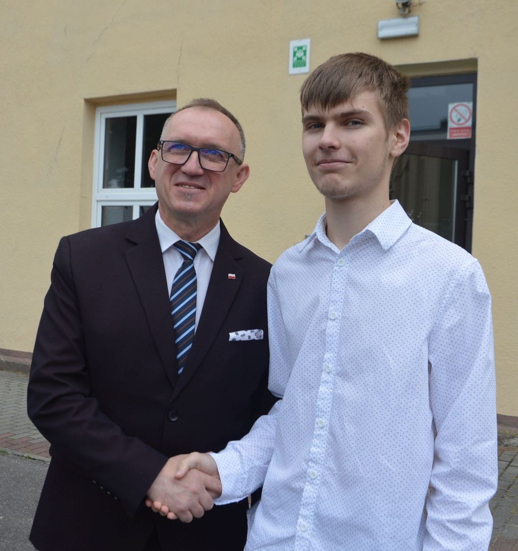Koniec roku szkolnego w ILO w Końskich. Członek zarządu powiatu Dariusz Banasik gratuluje stypendyście prezesa Rady Ministrów Adamowi Domagale