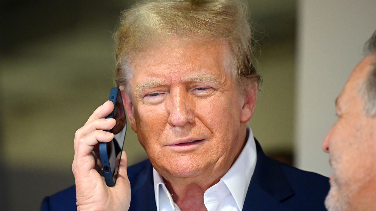 MIAMI, FLORIDA - MAY 05: Donald Trump talks on the phone in the McLaren garage prior to the F1 Grand Prix of Miami at Miami International Autodrome on May 05, 2024 in Miami, Florida. (Photo by Clive Mason/Getty Images)
