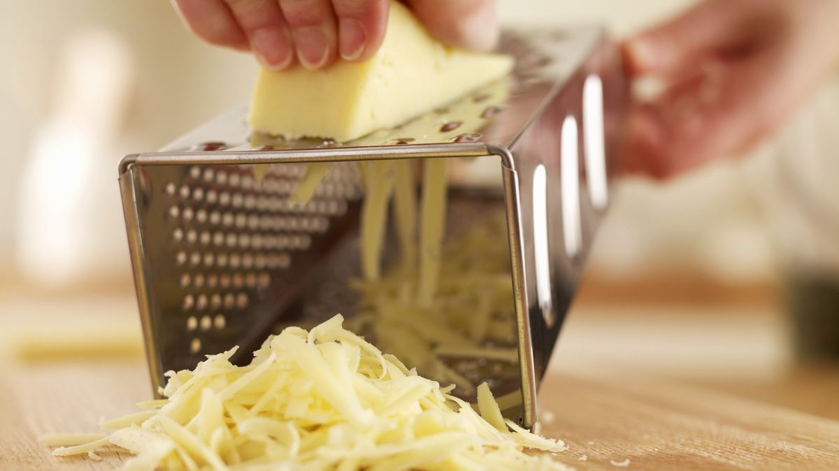 Woman shredded cheese with graterAdam Gault25-29 years, casual clothing, caucasian, cheese, cheese grater, close up, color image, cooking, dairy, domestic kitchen, domestic life, food and drink, freshness, front view, grating, holding, horizontal, indoors, ingredient, midsection, nourishing, nutrition, one person, people, photography, pile, preparation, shredding, wholesome, woman, young adult, young women
