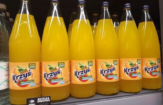 Napój Krzyś pomarańczowy w szklanym opakowaniu zwrotnym dostępny w Carrefour