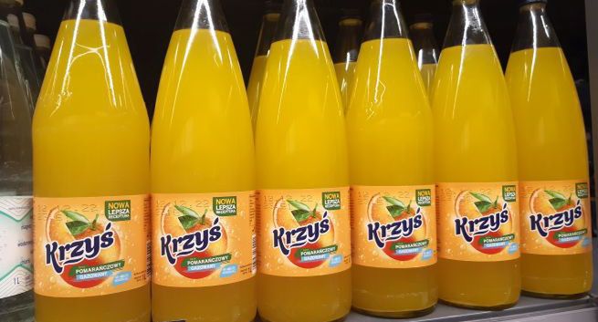 Napój Krzyś pomarańczowy w szklanym opakowaniu zwrotnym dostępny w Carrefour