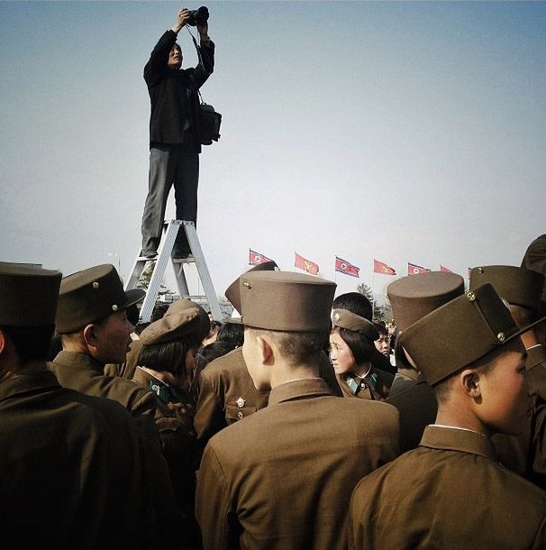 Fotograf wykonuje zdjęcie żołnierzy odwiedzających mauzoleum Kim Ir Sena