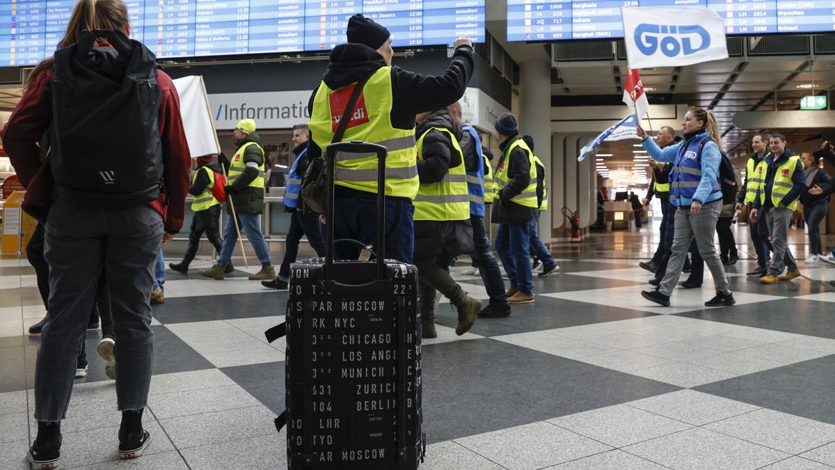 Ground services employees protest march past travelers during strike action at Munich International Airport in Munich, Germany, on Friday, Feb. 17, 2023. Germanys two largest airports, Frankfurt and Munich, came to a virtual standstill today as ground staff stage another strike over pay, exacerbating an already chaotic week for air travel after a system outage brought down Deutsche Lufthansa AGs operations two days ago. Photographer: Michaela Rehle/Bloomberg via Getty Images