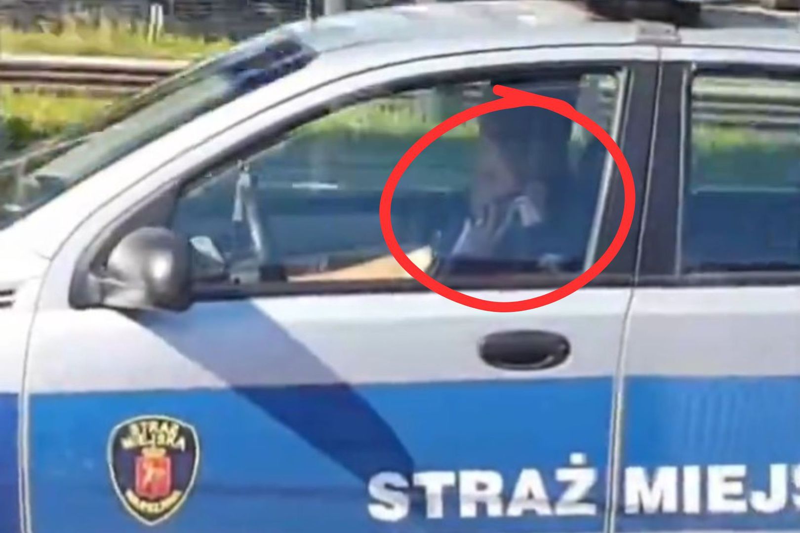 Strażniczka miejska z Warszawy prowadzi i rozmawia przez komórkę