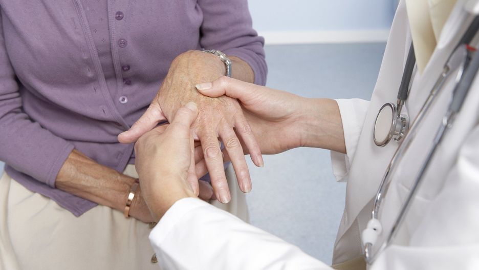 Rheumatoid arthritis, general practitioner examining patient and hand for signs of rheumatoid arthri