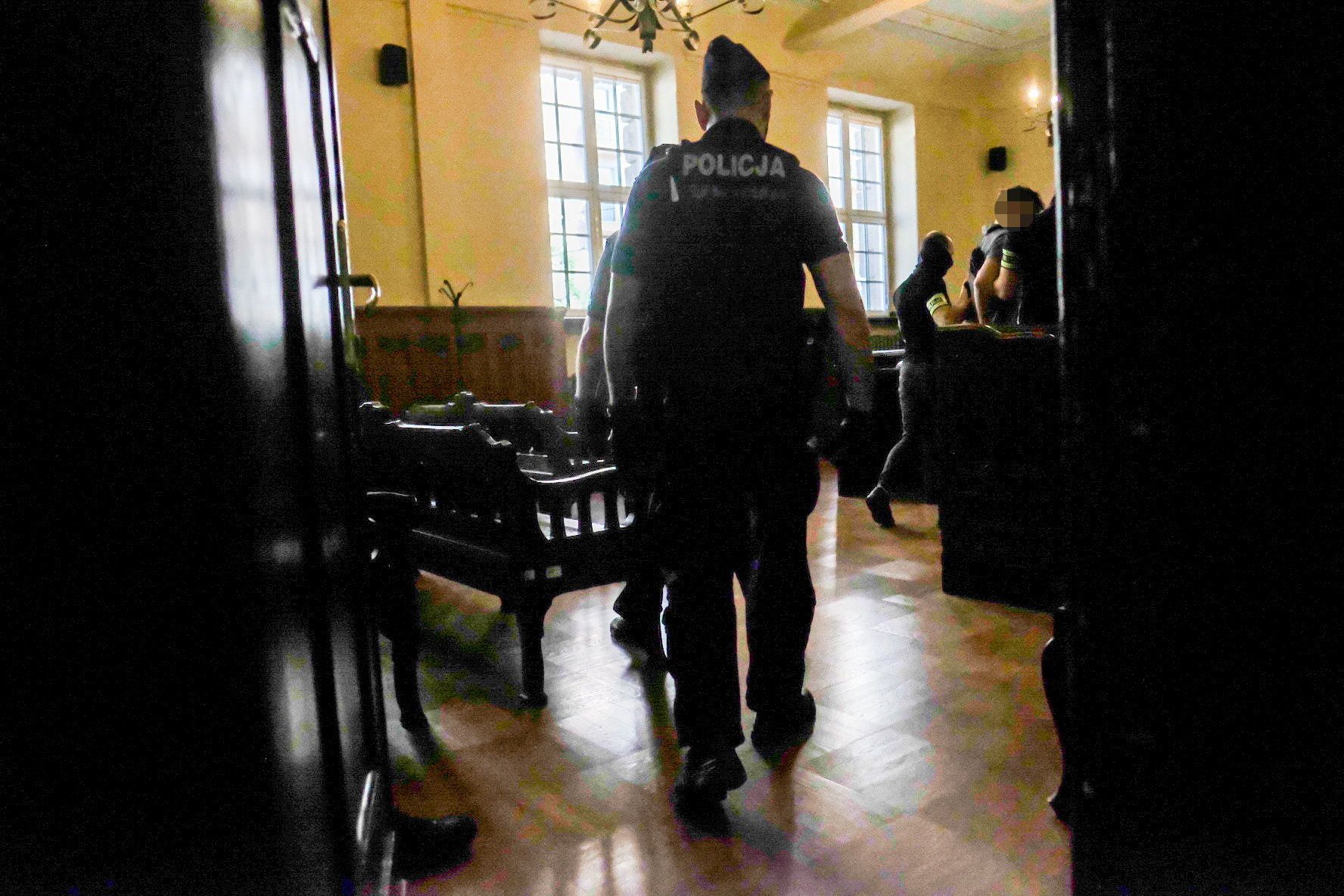 Policjanci prowadzą do sali rozpraw 17-letniego Alana O. Sąd w Poznaniu, 25 lipca 2022 roku