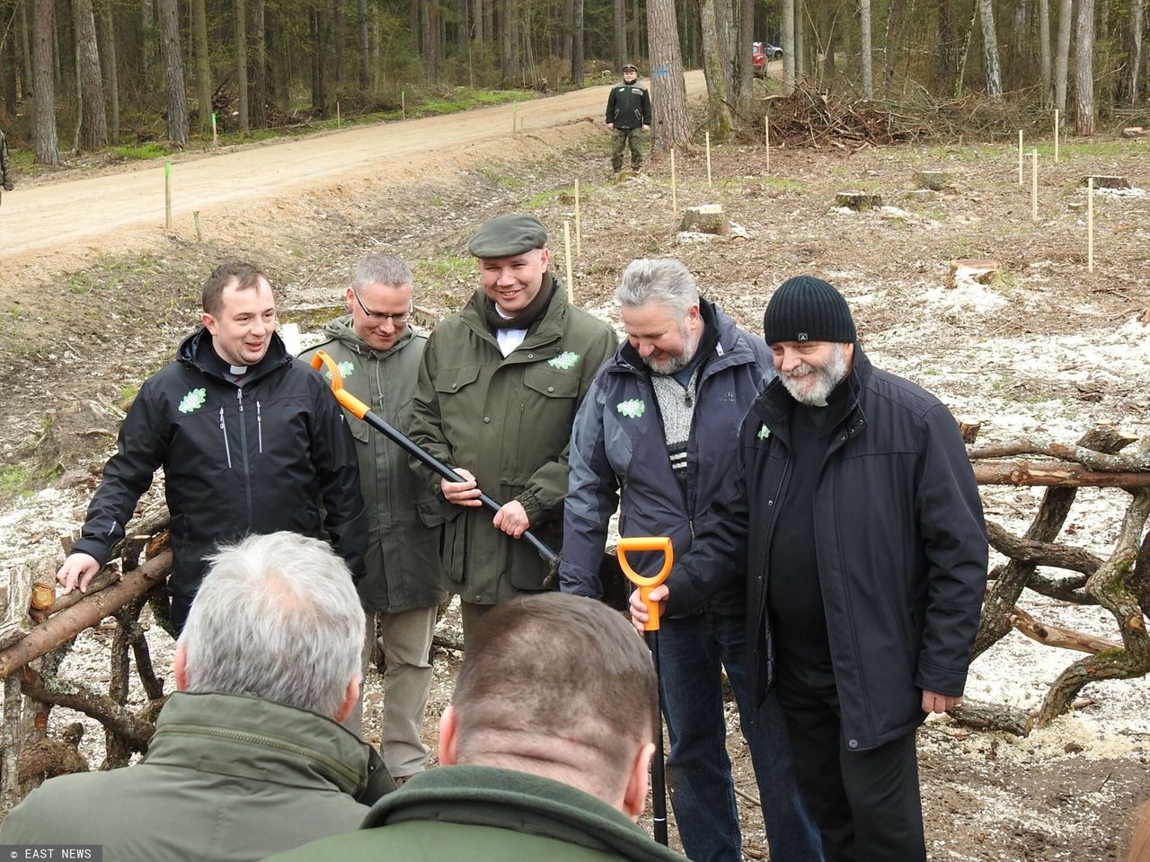 Sadzenie drzew w Puszczy Białowieskiej. W środku ks. Duszkiewicz. Za plecami grupki mężczyzn widoczne miejsce wyrębu drzew