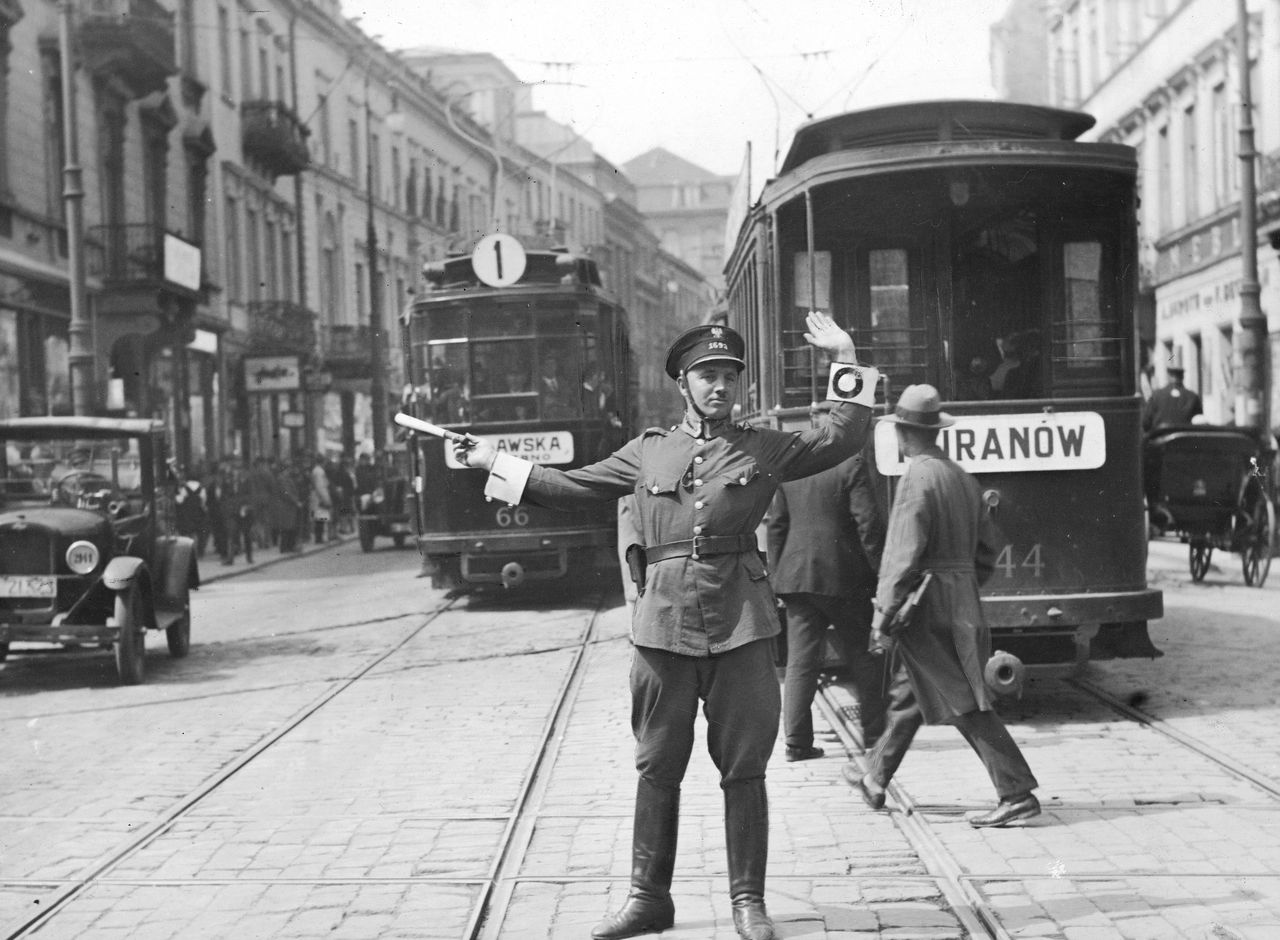 Warszawa. Policjant kierujący ruchem na ulicy Nowy Świat. Widoczny tramwaj linii nr 1.