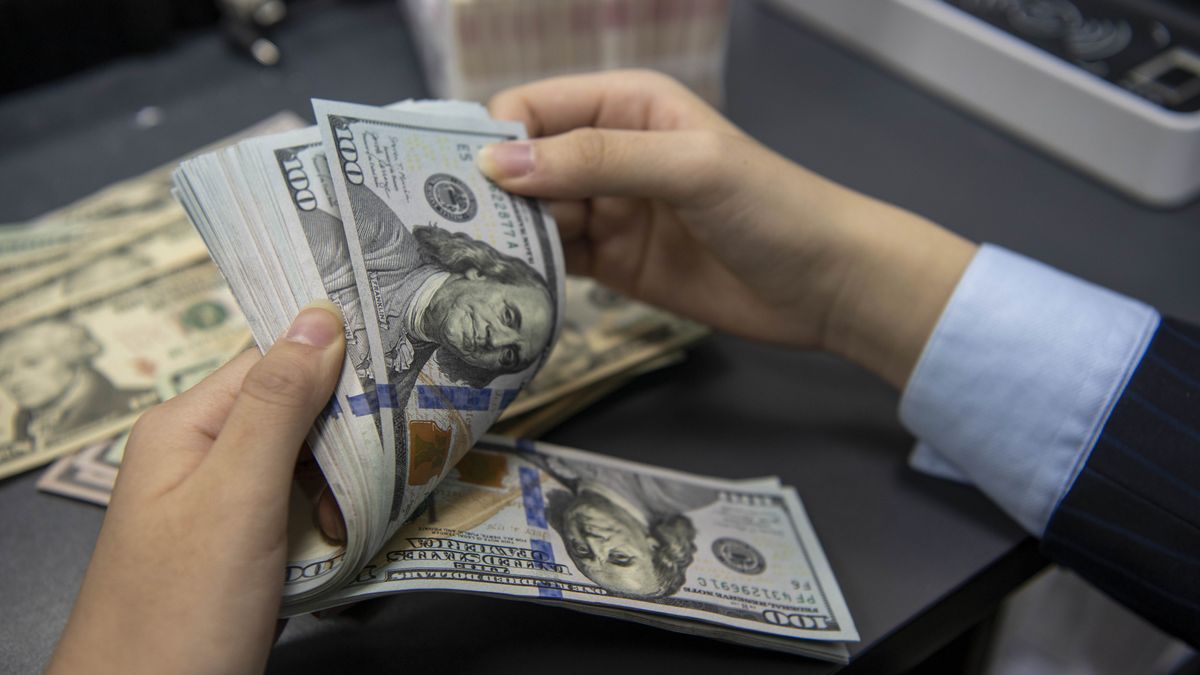 HAI'AN, CHINA - OCTOBER 22 2021: A clerk counts US dollar banknotes at a bank outlet in Hai'an city in east China's Jiangsu province Friday, Oct. 22, 2021. China has over 3.2 trillion dollars worth of foreign reserve by the end of September. (Photo credit should read Feature China/Barcroft Media via Getty Images)