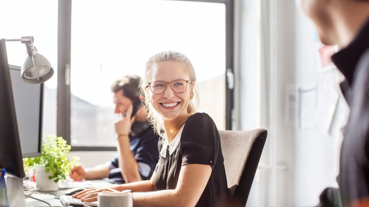Happy young businesswoman coworking with her teamSmiling young woman looking at her male colleague and smiling. Happy young businesswoman coworking with her team in new office.Luis Alvarez