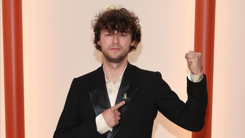Oscary 2023. Mateusz Kościukiewicz pozuje na szampańskim dywanie