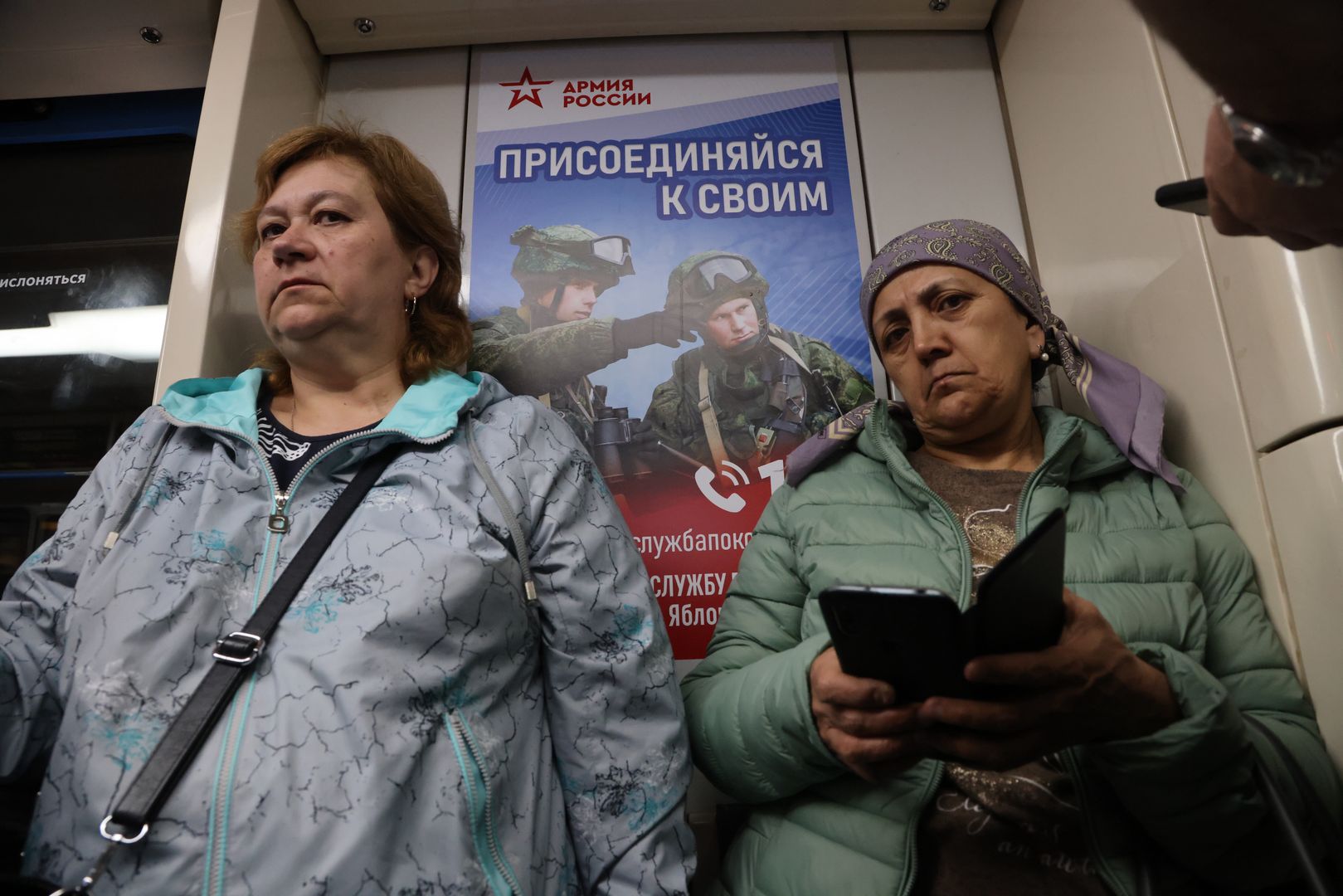 Daily Life In MoscowMOSCOW, RUSSIA - MAY 25: (RUSSIA OUT) Passengers ride a subway train as a military propaganda poster, advertising joining the army, is seen behind them on May 25, 2023, in Moscow, Russia. (Photo by Contributor/Getty Images)Contributor