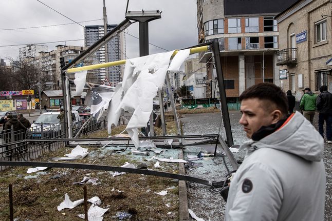 Ludzie przyglądają się zniszczeniom po ostrzale rakietowym w Kijowie.