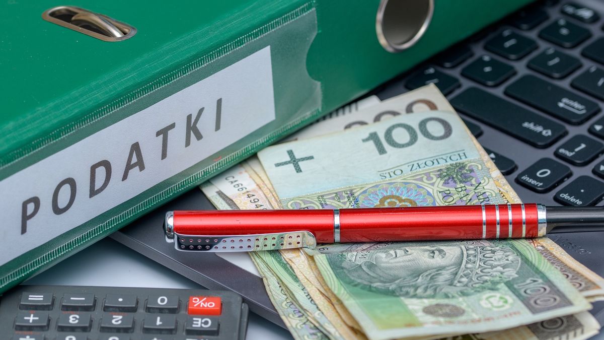 Polish taxes, computer binder and calculator lying on the deskA binder with the Polish inscription taxes next to a calculator, PLN cash, a laptop.  Settlements with the tax office, ZUSPawel Kacperek