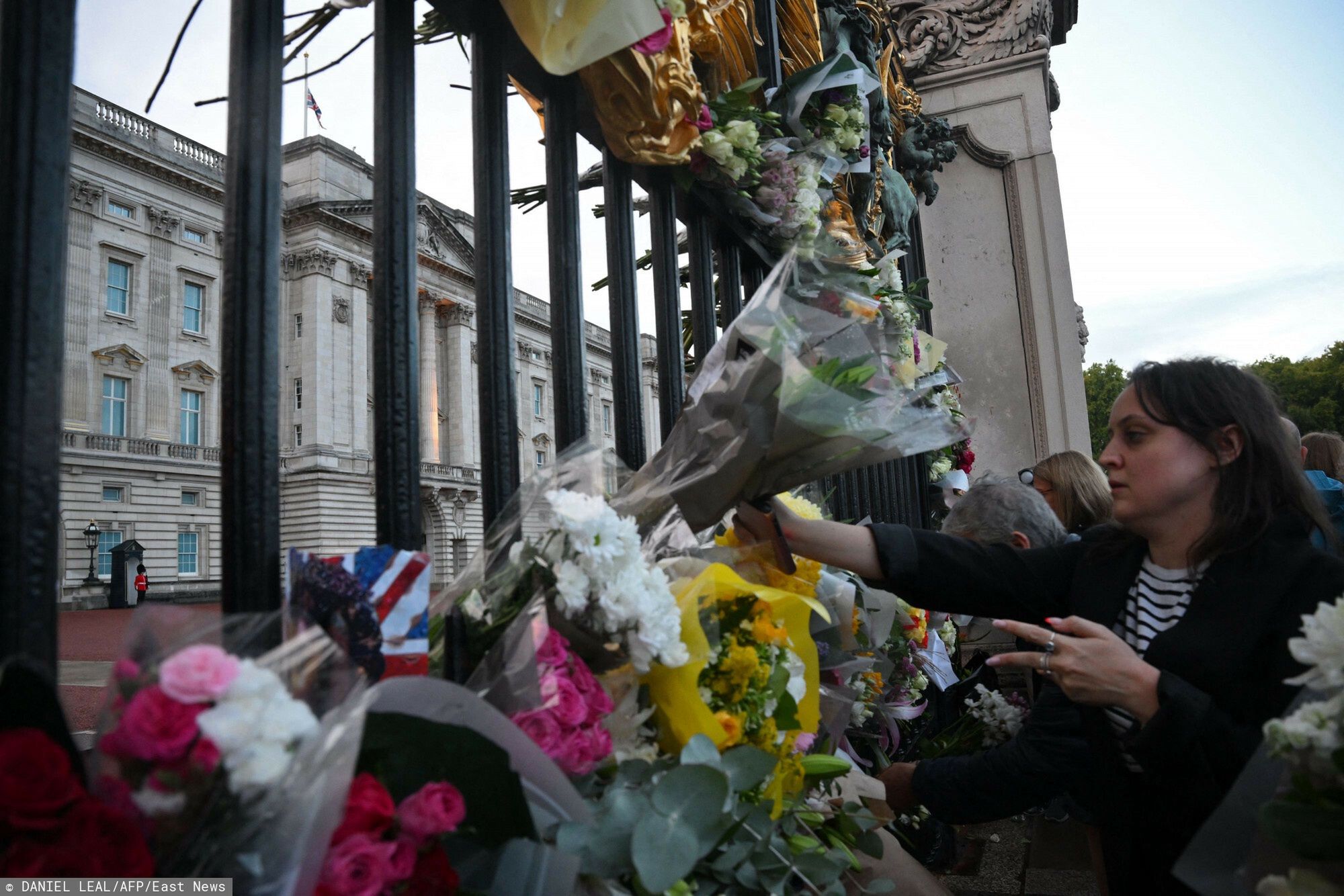 Sytuacja przed Pa?acem BuckinghamWellwishers arrive to place flowers at the gates of Buckingham Palace, after the announcement of the death of Queen Elizabeth II, in central London on September 8, 2022. - Queen Elizabeth II, the longest-serving monarch in British history and an icon instantly recognisable to billions of people around the world, has died aged 96, Buckingham Palace said on Thursday. (Photo by Daniel LEAL / AFP)DANIEL LEAL