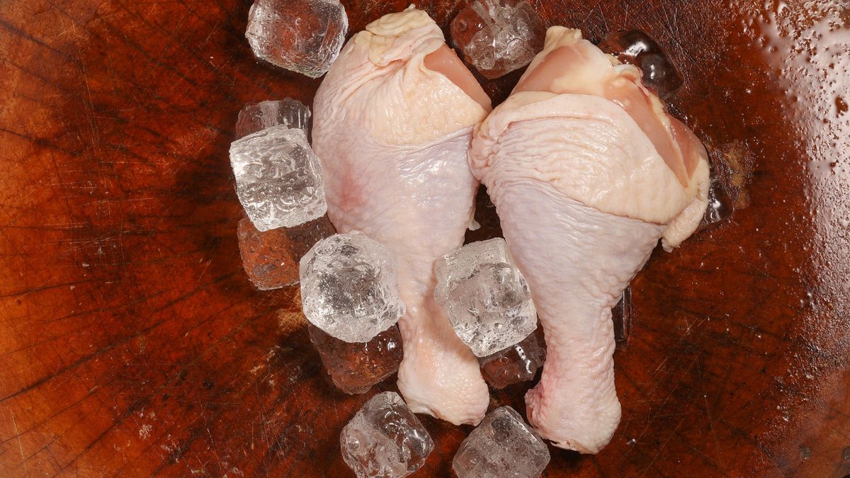 Chicken legs with ice on the chopping board
The drumsticks are on the chopping board
00one