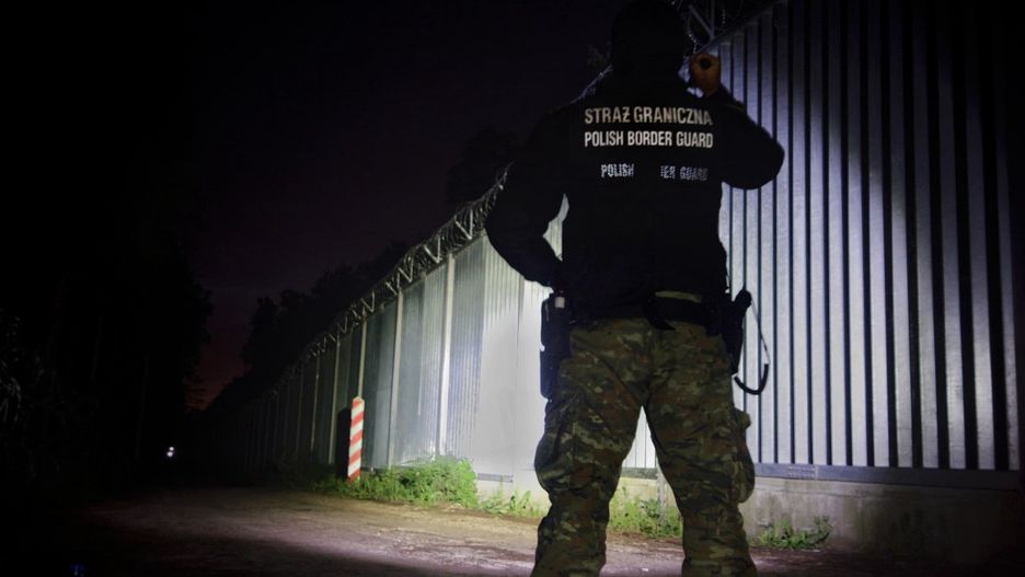 Kryzys migracyjny na granicy polsko-białoruskiej. Na fot. strażnik sprawdza stan bariery 