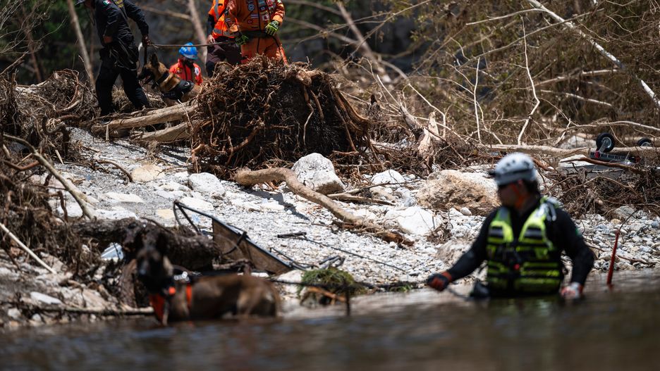 A group of volunteer rescuers from Mexico comb through flood debris with Mexican State Police and firefighters outside of Camp Mystic in Hunt, Texas, US, on Thursday, July 10, 2025. Crews in central Texas are digging through massive piles of debris, overturned vehicles and shattered homes as the search continues for victims of flash floods that killed more than 100 people over the Fourth of July weekend. Photographer: Eli Hartman/Bloomberg via Getty Images
