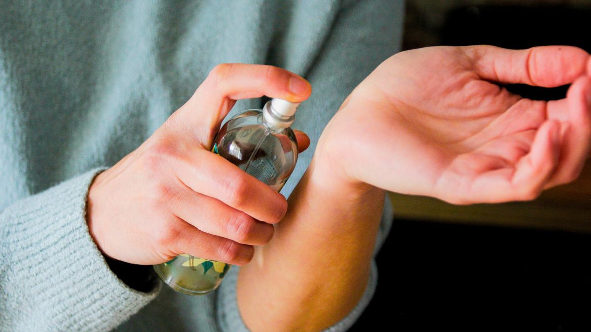 Kobieta pryska rękę perfumami