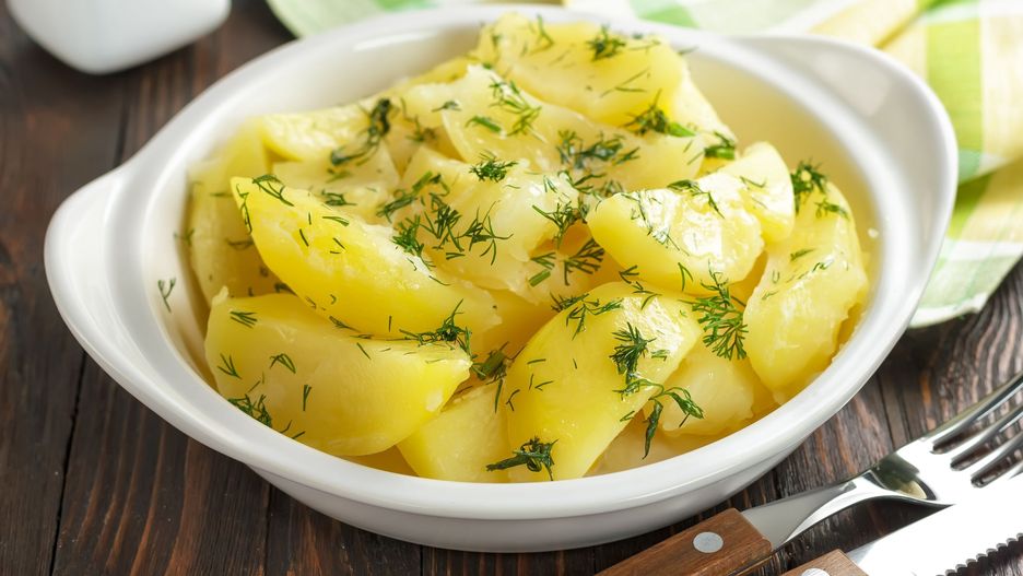 Ziemniaki z masłem i koperkiem na talerzu