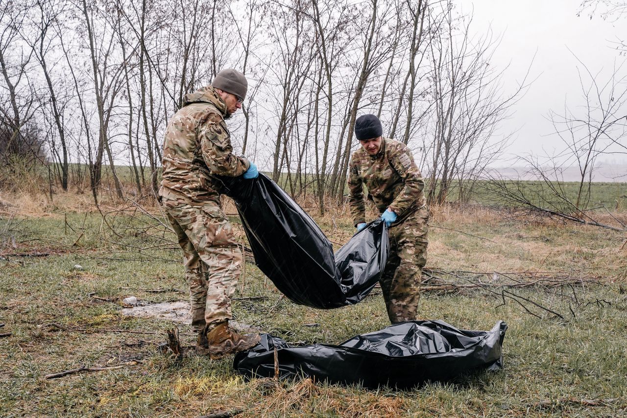 Ukrainian military personnel are moving the bodies of dead Russian soldiers found in the Kharkiv region.