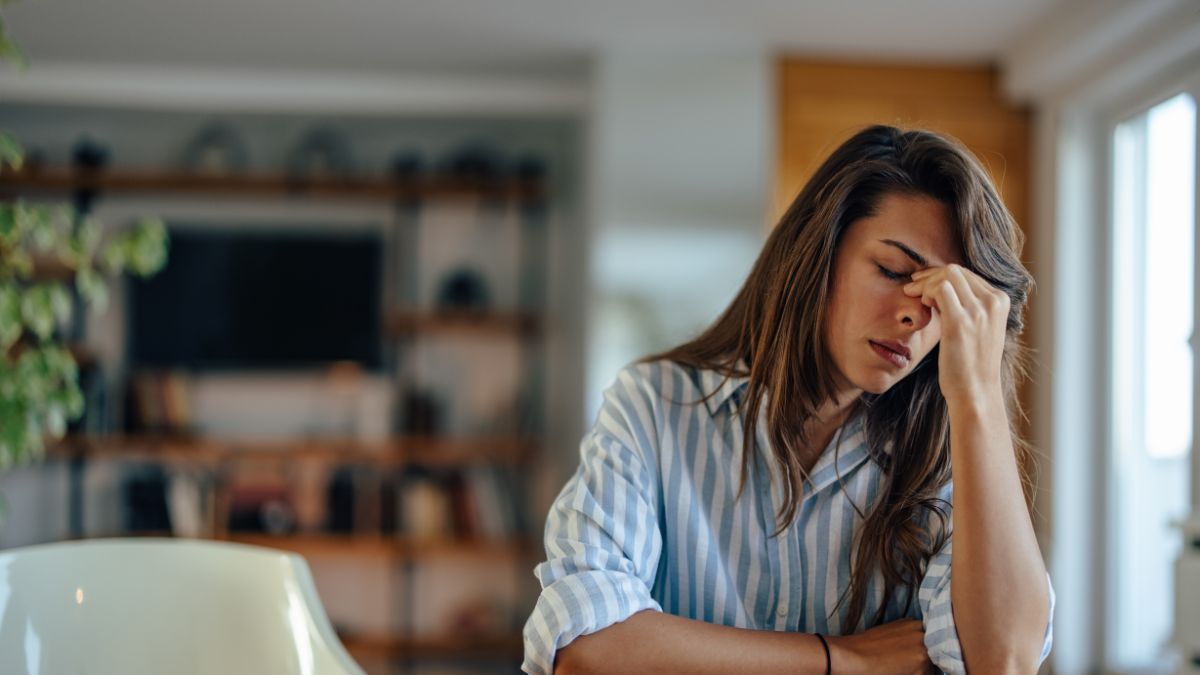 Zestresowana kobieta siedzi przy stole.