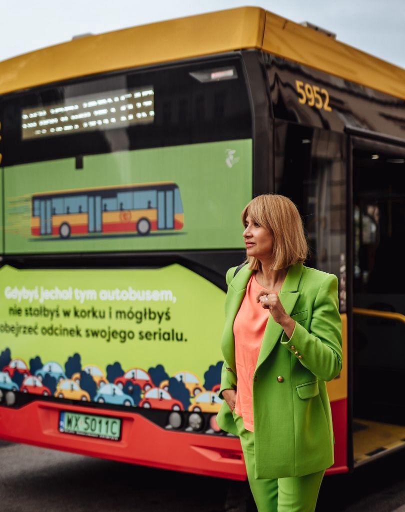 Grażyna Wolszczak "zaprzyjaźnia się"z komunikacją miejską, pozując na tle autobusu