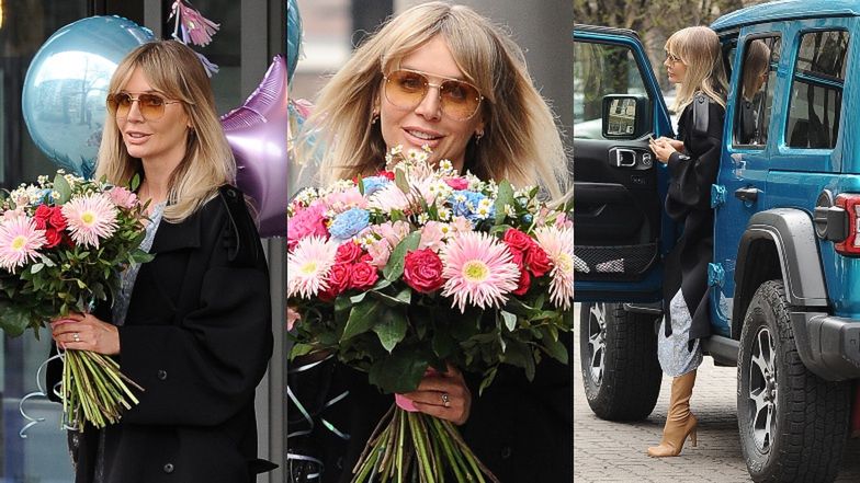 Agnieszka Woźniak-Starak wychodzi z pracy obładowana urodzinowym bukietem i balonami