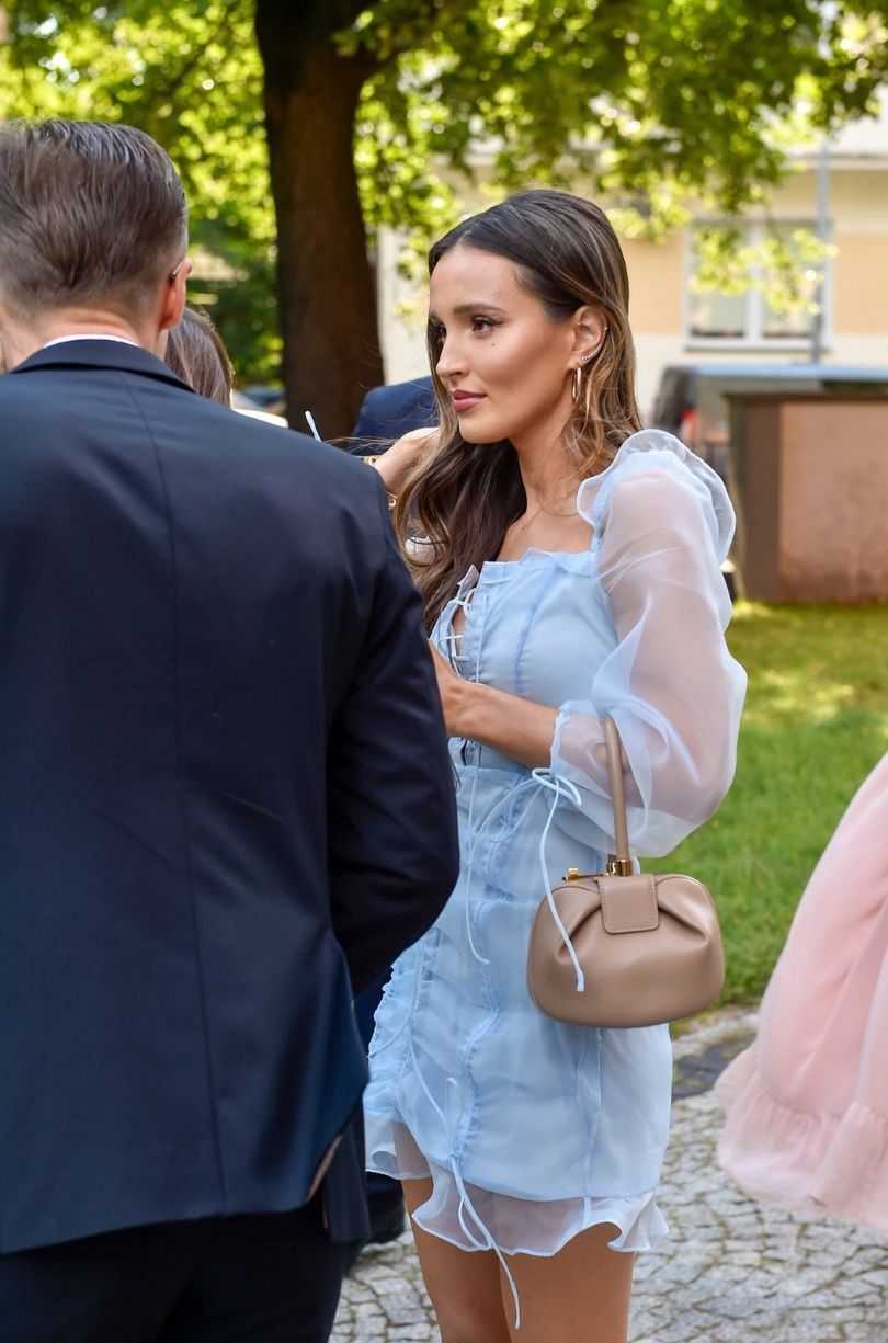 Marina Łuczenko gawędzi ze znajomymi na ślubie Antka Królikowskiego i Joanny Opozdy