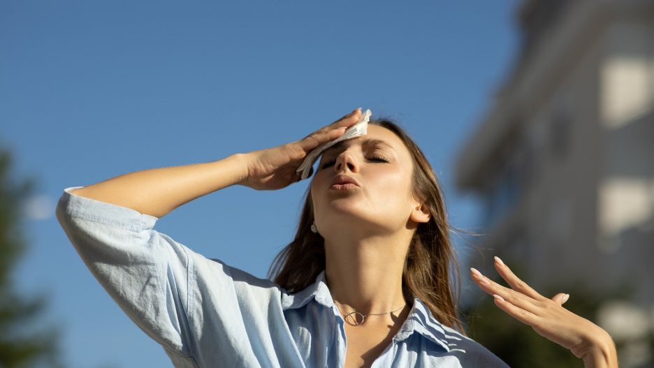 Woman drying sweat in a warm summer day