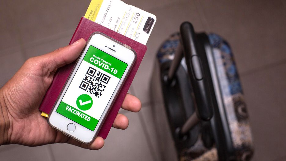 SPAIN - 2021/04/09: In this photo illustration, a passport, the European Commission (EC) logo and a symbolic COVID-19 health passport seen displayed on a smartphone screen. (Photo Illustration by Thiago Prudencio/SOPA Images/LightRocket via Getty Images)