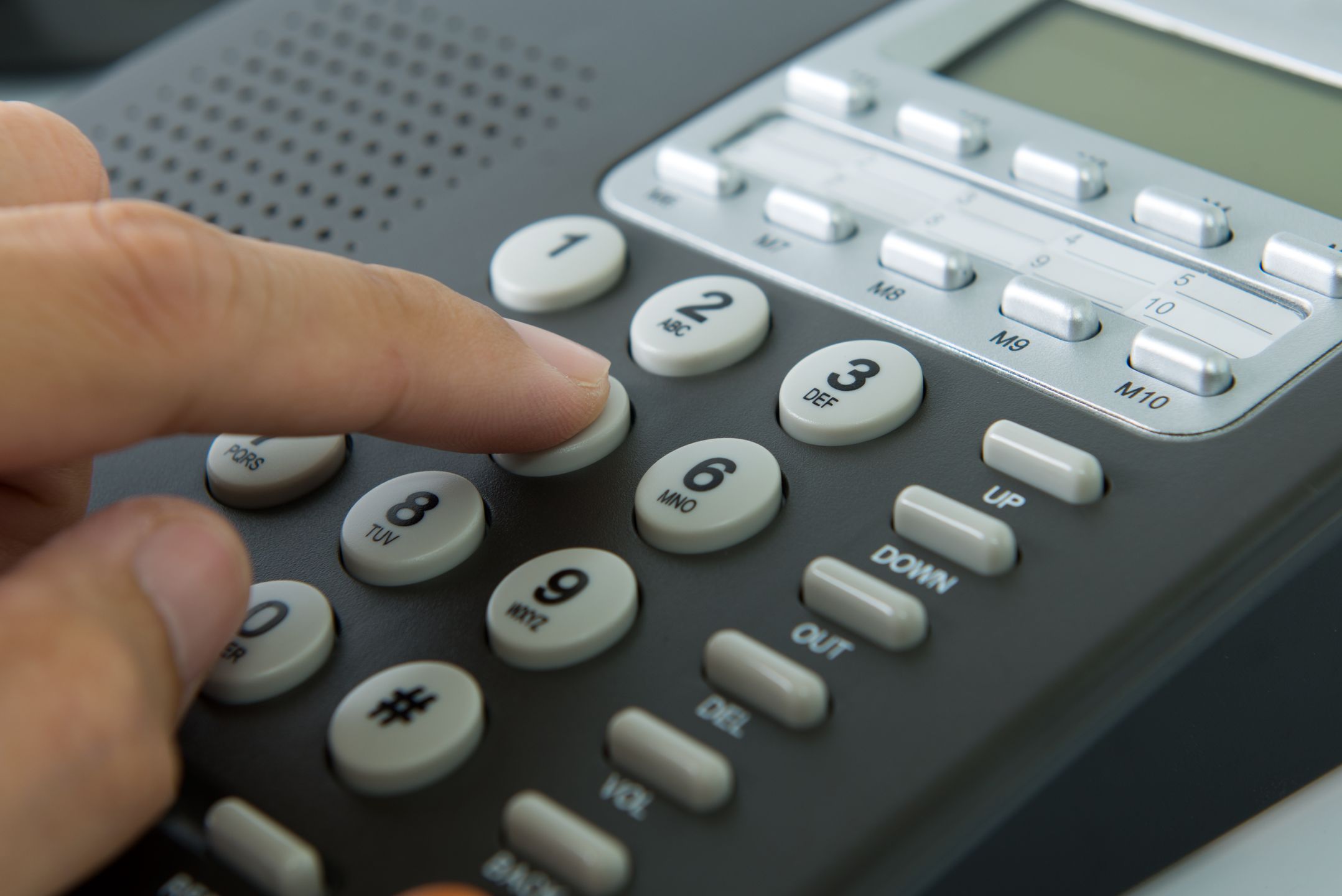 Close up of man dialing on a landline telephone