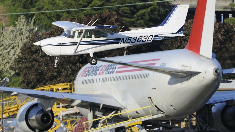UIG Aviation-imagesCessna 172P Skyhawk landing with Airborne Express Boeing 767-200 freighter parked behind.Aviation-images