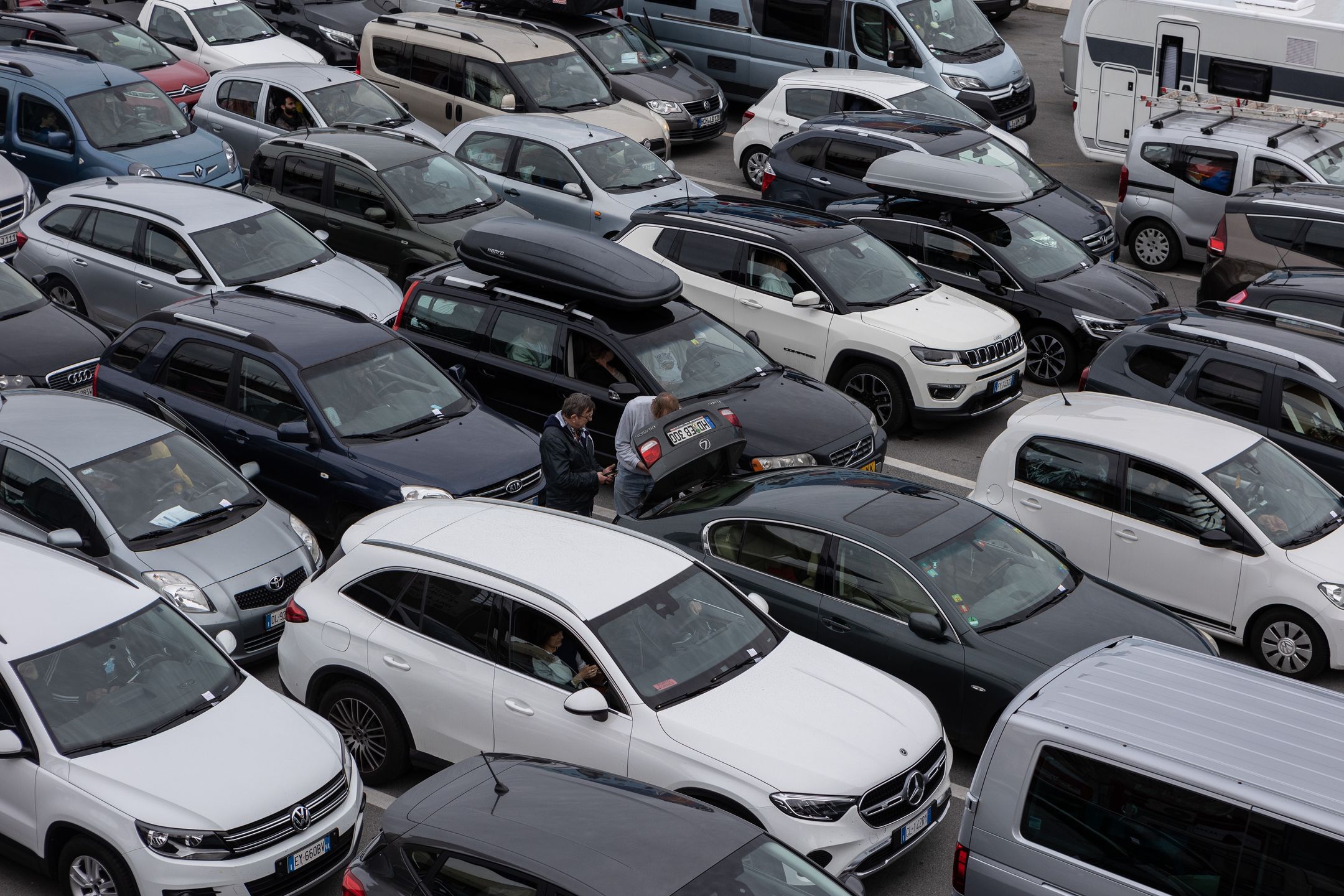 GENOA, ITALY - APRIL 23: Passengers stand next to their vehicles lined up waiting to board on the Italian shipping company Tirrenia’s Athara Ro-Ro/Passenger Ship (not i picture), berthed in the port on April 23, 2023 in Genoa, Italy. The Genoa Port is the busiest seaport of Italy, featuring an annual capacity of 4 million ferry and cruise passengers, 1.5 million cars and 250.000 trucks. (Photo by Emanuele Cremaschi/Getty Images)