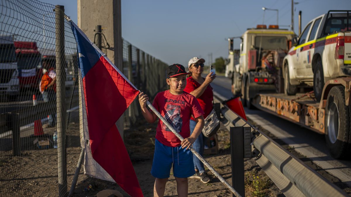 A boy holds a Chilean flag. 
During the second day of the Paine Truck Owners' and Drivers' Union strike in the road at the southern entrance to Santiago de Chile, On November 22, 2022. The protest is against the high cost of living, rising fuel prices and insecurity on the roads.  (Photo by Claudio Abarca Sandoval/NurPhoto via Getty Images)