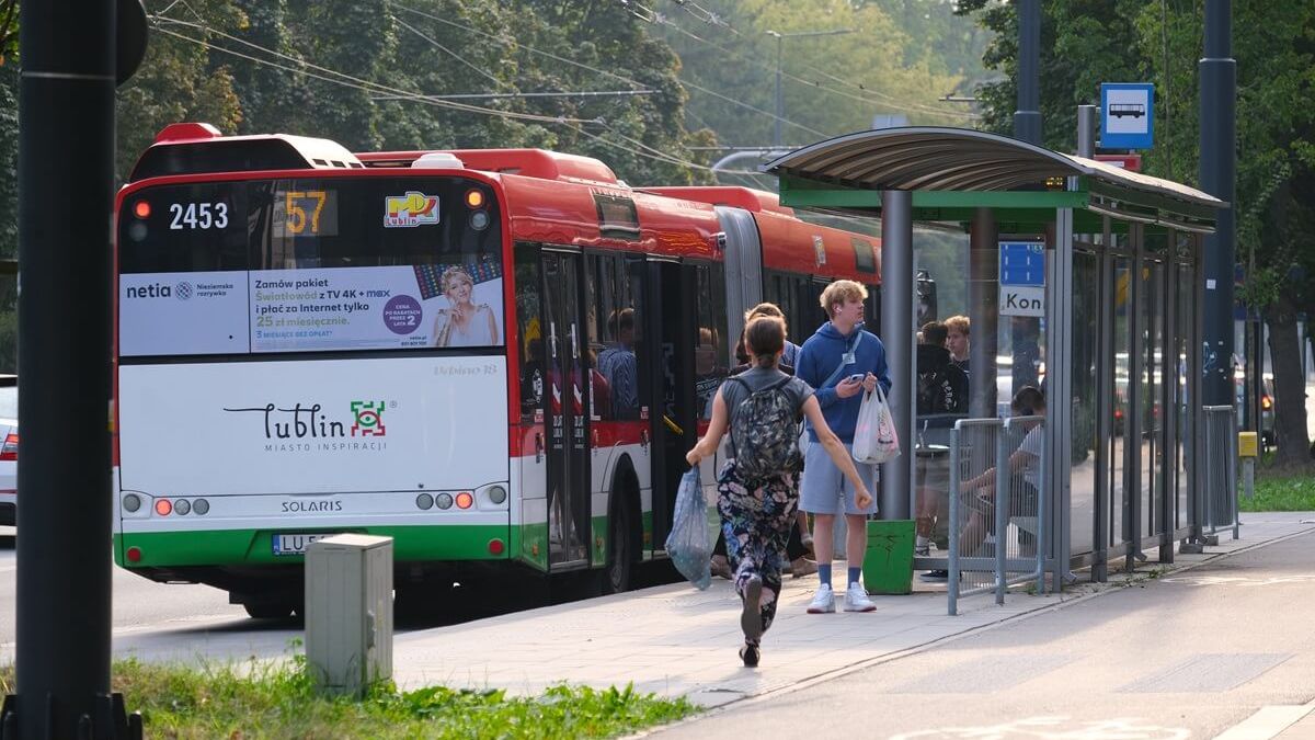 Kobieta biegnąca na autobus oczekujący na przystanku