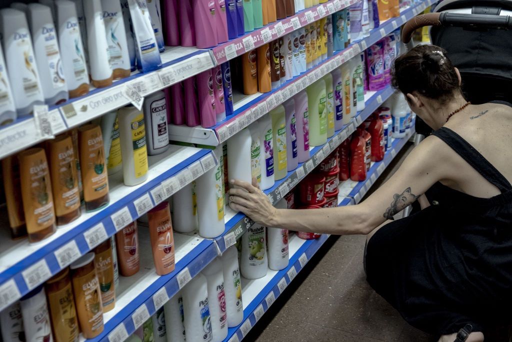 Na zdjęciu kobieta wybierająca kosmetyki