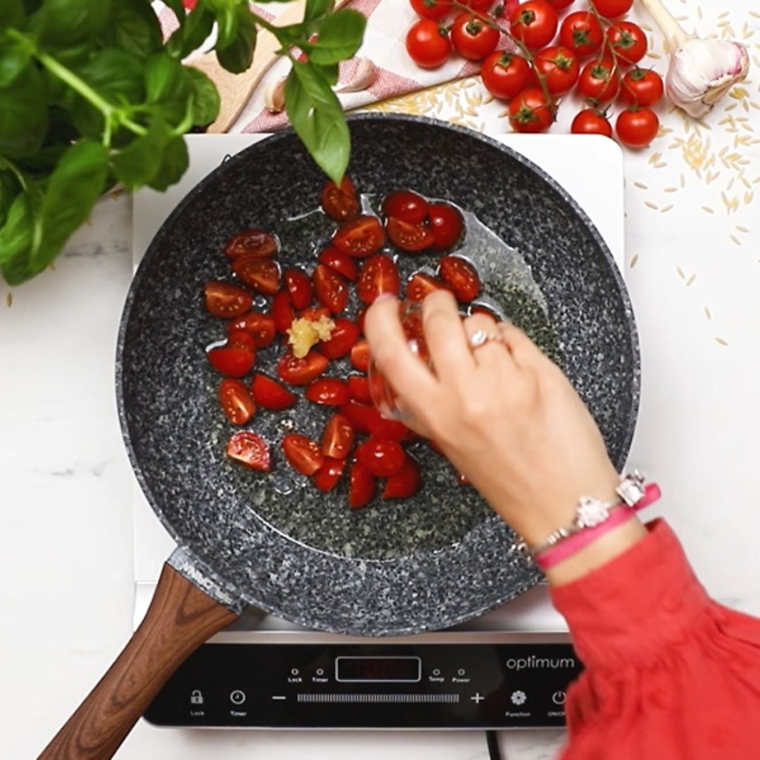 First, the tomatoes and garlic go into the pan.