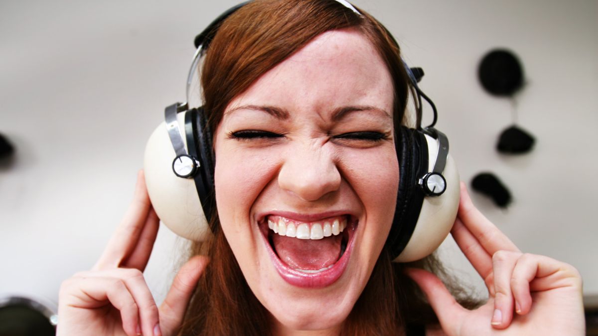 Kobieta w słuchawkach na uszach, śpiewa piosenki