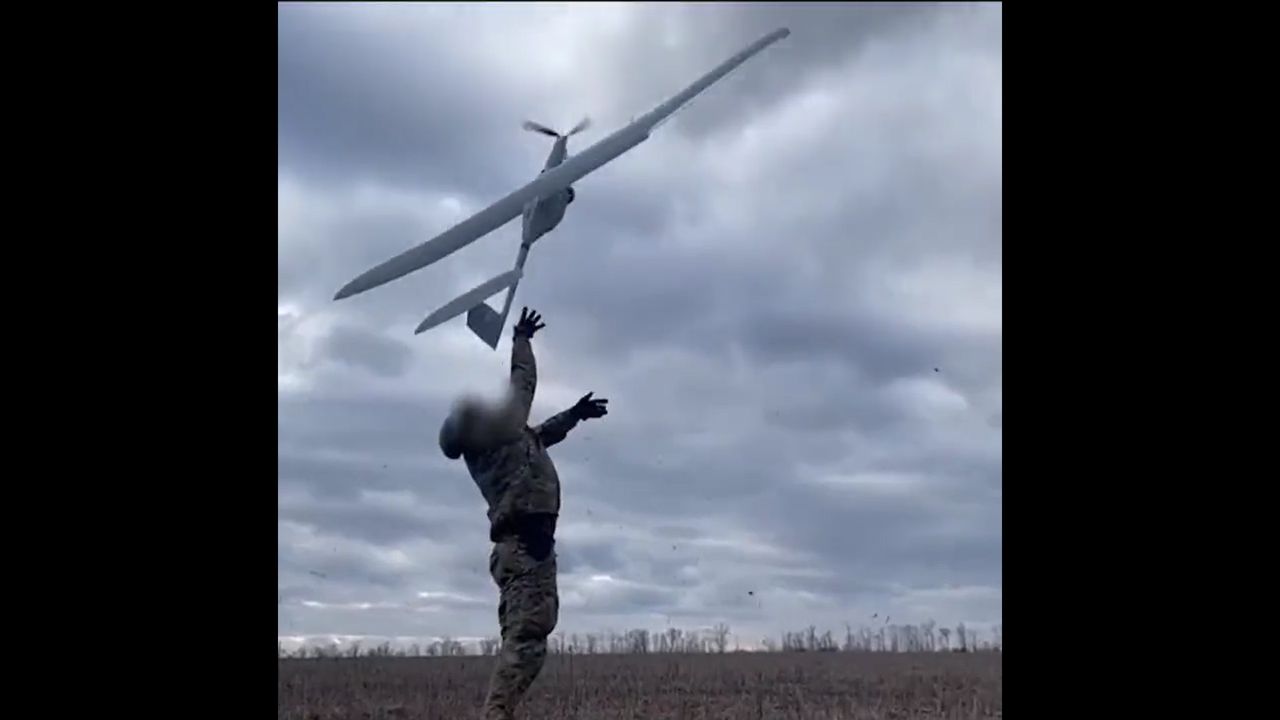 Ukraiński żołnierz wypuszczający drona FlyEye na zwiad.