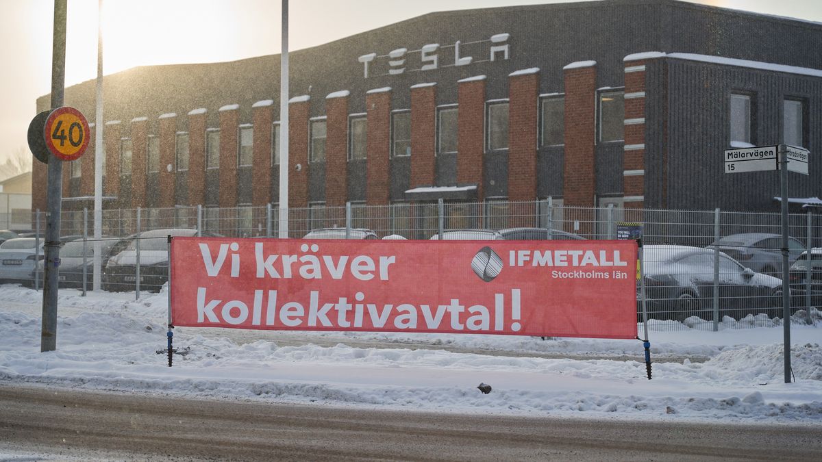 A banner from IF Metall union reading "We Demand a Collective Agreement" during a labor protest outside the Tesla Inc. service center in Segeltorp, Sweden, on Tuesday, Dec. 5, 2023. Tesla's deliveries to Sweden are at risk of being blocked from across the Nordic region after unions asked their neIFhboring peers to bolster their weeks-long strike. Photographer: Erik Flyg/Bloomberg via Getty Images